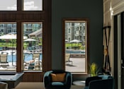 Thumbnail 42 of 44 - a living room with a view of a swimming pool at The Clearing at ONE28, Olathe, KS