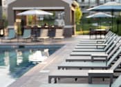 Thumbnail 15 of 44 - a row of lounge chairs next to a pool at The Clearing at ONE28, Olathe, 66062
