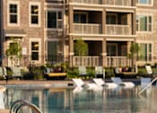 Thumbnail 14 of 44 - a swimming pool in front of an apartment building at The Clearing at ONE28, Olathe, Kansas