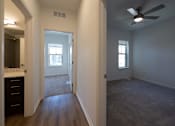 Thumbnail 34 of 44 - an empty living room with a ceiling fan and a bathroom at The Clearing at ONE28, Olathe, Kansas