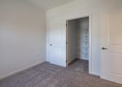 Thumbnail 35 of 44 - a room with white walls and a closet and a door to a closet at The Clearing at ONE28, Olathe, Kansas