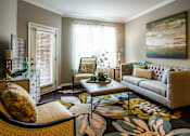 Thumbnail 18 of 59 - A living room with a couch, chair, and a painting on the wall.