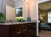 Thumbnail 23 of 59 - A bathroom with a vanity and a mirror.
