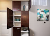 Thumbnail 17 of 59 - A brown cabinet with a white interior is open, revealing plates and bowls.