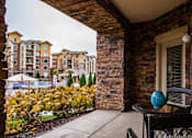Thumbnail 32 of 59 - A balcony with a table and chairs overlooking apartment buildings.