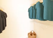 Thumbnail 36 of 44 - A row of teal shirts hanging on a white wall. at The Crest at Sugarloaf, Lawrenceville, GA