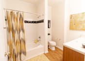 Thumbnail 27 of 44 - A bathroom with a shower curtain and a toilet. at The Crest at Sugarloaf, Lawrenceville, 30044