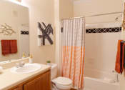 Thumbnail 21 of 44 - A bathroom with a white sink, toilet, and shower curtain. at The Crest at Sugarloaf, Lawrenceville, Georgia