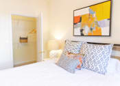 Thumbnail 19 of 44 - A bedroom with a bed, pillows, a painting, and a closet. at The Crest at Sugarloaf, Lawrenceville, 30044