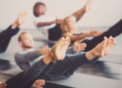 Thumbnail 60 of 66 - a group of people sitting in a yoga class with their hands up at District at Riverside Apartments, Tennessee