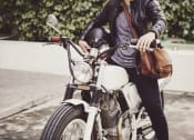 Thumbnail 56 of 66 - a woman sitting on a motorcycle with a bag at District at Riverside Apartments, Tennessee, 37406