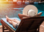 Thumbnail 59 of 60 - a woman in a straw hat lies on a chaise lounge by a pool at The Crest at South Point, Georgia