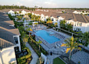Thumbnail 7 of 33 - A swimming pool surrounded by palm trees and a gated fence at The Crest at Laurel Canyon Apartments, Florida, 34113