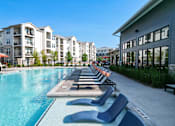 Thumbnail 12 of 30 - Resort style pool with lounge chairs and tanning ledge at The Crest at Acworth Apartments, Acworth, Georgia
