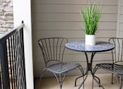 Thumbnail 9 of 27 - a patio with a table and three chairs at The Crest at Laurel Canyon Apartments, Canton, 30114