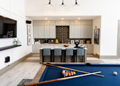 Thumbnail 20 of 30 - Game room with pool table and kitchen area at The Crest at Acworth Apartments, Acworth