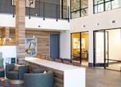 Thumbnail 27 of 66 - A reception area with a white counter and grey chairs.at Riverside Apartments, Chattanooga, 37406