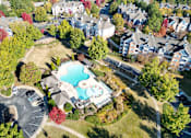 Thumbnail 2 of 44 - An aerial view of a residential area with a swimming pool and apartment buildings. at The Crest at Sugarloaf, Lawrenceville