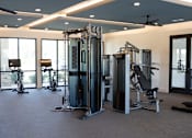Thumbnail 41 of 60 - A gym with a variety of equipment including a squat rack, a leg press machine, and a bench press.