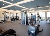 Thumbnail 47 of 60 - A gym with a variety of equipment including treadmills, weights, and a rowing machine at The Crest at South Point Apartments, McDonough, 30253