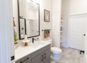 Thumbnail 7 of 66 - A bathroom with a toilet, sink, and mirror.