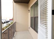 Thumbnail 11 of 66 - A balcony with a black railing and a window with white blinds.