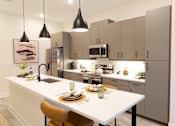 Thumbnail 2 of 66 - A modern kitchen with a white island and grey cabinets.