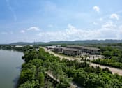 Thumbnail 1 of 72 - A large building complex sits on the bank of a river.