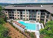 Thumbnail 2 of 72 - A large apartment complex with a pool.