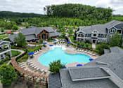 Thumbnail 1 of 27 - an aerial view of a resort style pool with lounge chairs and umbrellas at The Crest at Laurel Canyon Apartments, Canton, Georgia