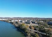 Thumbnail 1 of 66 - A river flows through a city with a bridge crossing over it.at Riverside Apartments, Chattanooga, TN