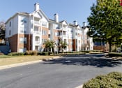 Thumbnail 1 of 44 - A large apartment complex with a parking lot in front. at The Crest at Sugarloaf, Lawrenceville