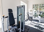 Thumbnail 9 of 44 - A gym with a black chair and a black and silver machine. at The Crest at Sugarloaf, Lawrenceville, Georgia