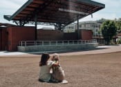 Thumbnail 38 of 46 - a girl and her dog sitting in front of a bandstand at The Wren Apartments, Lawrenceville, Georgia