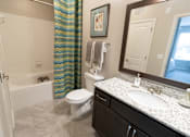 Thumbnail 5 of 27 - a bathroom with a white toilet next to a bathtub at The Crest at Laurel Canyon Apartments, Georgia