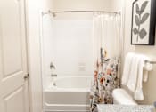 Thumbnail 6 of 30 - Bathroom with tub shower combo and floral curtain at The Crest at Acworth Apartments, Acworth, 30102