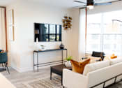 Thumbnail 14 of 66 - A living room with a white couch, a black coffee table, and a ceiling fan.at Riverside Apartments, Chattanooga, 37406