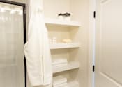 Thumbnail 18 of 66 - A white towel hangs on a white shelf in a bathroom.at Riverside Apartments, Chattanooga, Tennessee