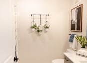 Thumbnail 23 of 66 - A bathroom with a towel hanging on the wall and a plant on the counter.at Riverside Apartments, Chattanooga, 37406