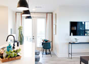 Thumbnail 13 of 66 - A modern kitchen with a black pendant light and a wooden tray with greenery on the counter.at Riverside Apartments, Chattanooga, Tennessee