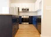 Thumbnail 26 of 27 - A kitchen with dark blue cabinets and a white countertop.