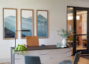 Thumbnail 11 of 27 - A reception desk with a chair and a plant in front of it.