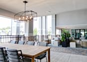 Thumbnail 7 of 27 - A modern dining area with a long wooden table and chairs.