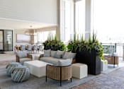 Thumbnail 8 of 27 - A modern outdoor seating area with a variety of furniture and plants.