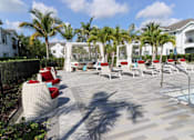 Thumbnail 15 of 33 - a pool with lounge chairs and palm trees at The Crest at Laurel Canyon Apartments, Florida, 34113