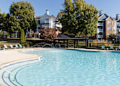 Thumbnail 3 of 44 - A large swimming pool surrounded by trees and chairs. at The Crest at Sugarloaf, Lawrenceville, GA