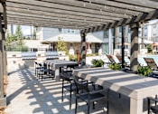 Thumbnail 24 of 30 - Outdoor grilling area with pergola and dining tables at The Crest at Acworth Apartments, Georgia, 30102