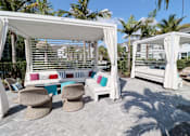 Thumbnail 16 of 33 - a covered patio with chairs and a hammock at The Crest at Laurel Canyon Apartments, Florida