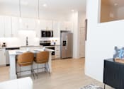Thumbnail 2 of 53 - Bright minimalist kitchen with Table and Chairs at District on the Etowah Apartments, Canton, GA