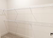 Thumbnail 8 of 53 - Soothing calm closet with white shelves at District on the Etowah Apartments, Canton, GA 30114